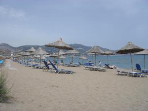 a group of chairs and umbrellas on a beach at La Santre Villa in Amoudara Herakliou
