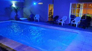 una piscina con sillas y una iluminación azul en Hotel Jardin del Lago, en Villa Carlos Paz