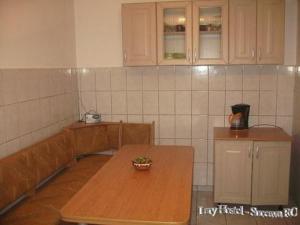 a kitchen with a wooden table in a room at Lary Hostel in Suceava