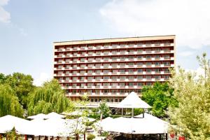 un hôtel avec un grand bâtiment en arrière-plan dans l'établissement Rila Hotel Sofia, à Sofia