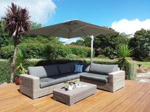 a patio with a couch and an umbrella at Applecross Sanctuary in Cambridge