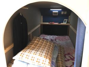 a small bedroom with a bed in an archway at Hiroshima Guesthouse HARU in Hiroshima