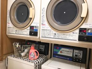 a washing machine and a dryer in a room at Hiroshima Guesthouse HARU in Hiroshima