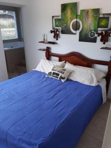 1 dormitorio con cama azul y edredón azul en Complejo Sol&Luna en Villa Ventana