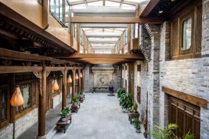 a hallway with benches and plants in a building at Water Hotel, Pingyao in Pingyao