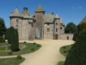 un vieux château avec un chemin en face de lui dans l'établissement Hôtel restaurant Notre Dame, à Orcival