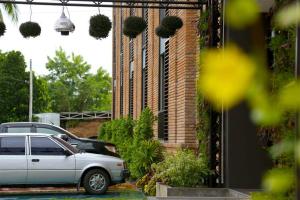 a silver car parked in front of a brick building at The Coconut Hotel in Lampang