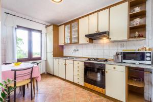 kuchnia z kuchenką i stołem w obiekcie Apartment Stelia w mieście Mednjan