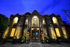 two people in gold costumes standing in front of a house at Northern Breeze Hotel in Bagan