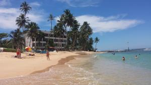 a group of people in the water on a beach at Cool Beach Hotel in Hikkaduwa