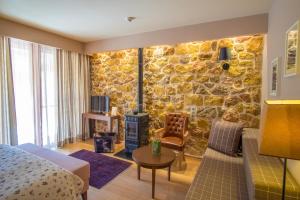 una habitación de hotel con una pared de piedra en Orizontes Tzoumerkon Hotel Resort en Prámanta