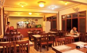 two people sitting at tables in a restaurant at Hotel Brihaspati Pvt Ltd in Kathmandu