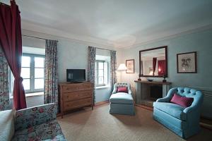 a living room with blue chairs and a television at La Locanda Di Cetona in Cetona