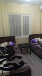 ゴルビツカヤにあるGuest House Freshのベッド2台とテーブルが備わる客室です。