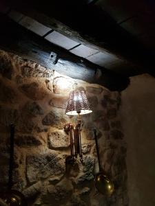 una lámpara en una pared de piedra en una habitación en Casa Angel en Sequeros