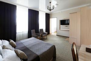ein Hotelzimmer mit einem Bett und einem TV in der Unterkunft Cronwell Park Nika in Omsk