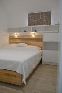 1 dormitorio con 1 cama grande y pared de ladrillo en Villa I Karma, en Tisno