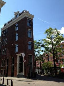 un edificio alto de ladrillo rojo en una calle de la ciudad en Linden Hotel, en Ámsterdam