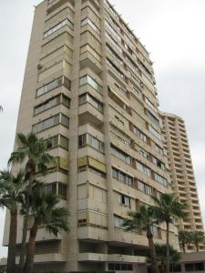 un edificio alto con palmeras delante en Apartamentos Mariscal VII, en Benidorm