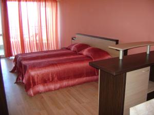 ポモリエにあるMak Complexのベッドルーム1室(赤いベッドカバー、テーブル付)