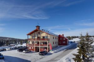 a large building with cars parked in a parking lot at Lillehammer Fjellstue og Hytteutleie in Nordseter