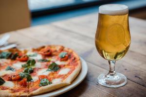 a pizza and a glass of beer on a table at Black Isle Bar & Rooms in Inverness