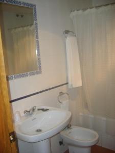 a bathroom with a sink and a toilet and a mirror at Hotel Hispanidad in Guadalupe