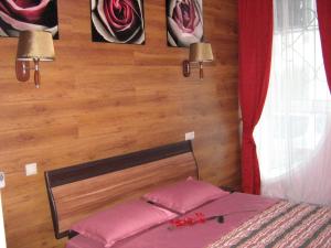 a bedroom with a bed with two pink pillows at Hotel Sfera Barnaul in Barnaul