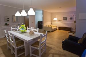 a kitchen and living room with a white table and chairs at La Maison di Brigitte e Simone in Bentivoglio
