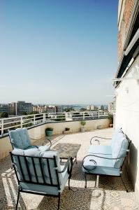 a patio with two chairs and a table on a balcony at Boem Apartment in Constanţa