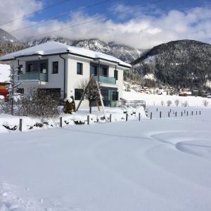 una casa en la nieve con un patio en WM-Appartements en Haus im Ennstal