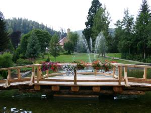 Landhaus Enztalperle في انزكلوسترل: جسر فوق بركة به نافورة