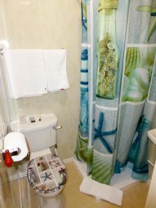 a bathroom with a toilet and a shower curtain at The Northwood in Colwyn Bay