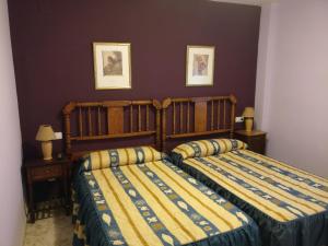 a bedroom with two beds and two pictures on the wall at Casa Cabriel in Villargordo del Cabriel