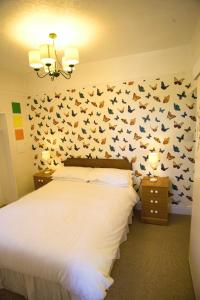 1 dormitorio con 1 cama con murciélagos en la pared en The Northwood, en Colwyn Bay