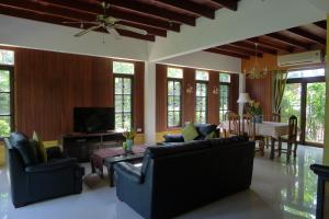 a living room with couches and a dining room at Symphony Villa in Nai Harn Beach
