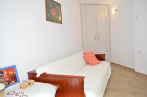 a living room with a white couch with an orange pillow at Apartment Andrija in Vrbnik