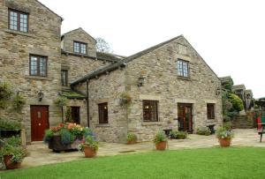 um edifício de pedra com vasos de plantas à sua frente em Pack Horse Inn em Mellor