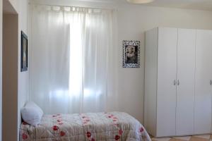 1 dormitorio con cama y ventana en Residence Shopping Outlet, en Novi Ligure