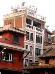 un edificio de ladrillo alto con un cartel encima en Looniva Guest House, en Pātan