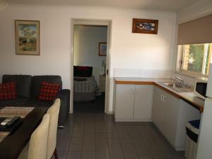 a kitchen and a living room with a couch at Old Coach Motor Inn Echuca in Echuca