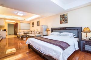 a bedroom with a large bed and a living room at The Legend Nuomo Service Apartment in Guangzhou