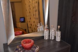 a mirror with bottles on a table in a room at Kalimera Apartment in Nafplio