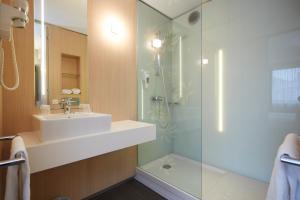 a bathroom with a sink and a shower at Mercure Valenciennes Centre in Valenciennes