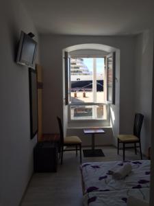 a room with a bed and a window with a view at Main Bus Station Rooms in Dubrovnik