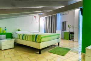 a bedroom with a large bed with green walls at Settessenze Residence & Rooms in Agropoli