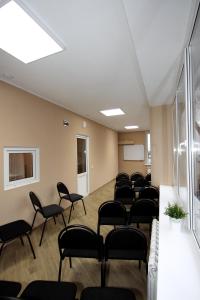 an empty room with chairs and a podium at London Apartment Hotel in Novokuybyshevsk