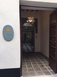 a hallway with a door and a clock on the wall at Casa Boutique La Pila del Pato in Seville