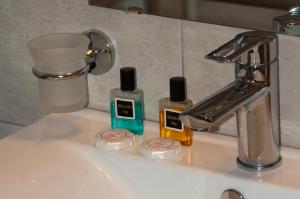 a bathroom sink with two bottles of soap and a faucet at Riviera Perdika Hotel in Perdika