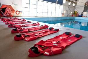 Hay una fila de nuevos alineados junto a una piscina. en RNLI College en Poole